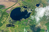 Luftaufnahme einer ruhigen ländlichen Landschaft mit einem ruhigen See und grünen Feldern mit einem Dorf, Nikitino, Kurgan Oblast, Russland