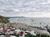 Der Hafen von Labuan Bajo mit einem im Meer segelnden Boot und dem Stadtbild, Touristenziel in Indonesien.