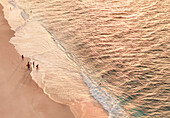Luftaufnahme eines schönen Sandstrands mit Menschen, die den Sonnenuntergang und die sanften Wellen genießen, Fuvahmulah, Malediven.