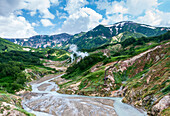 Luftaufnahme von unberührten Bergen und einem ruhigen Tal mit einem sich schlängelnden Fluss und geothermischem Dampf, Kronotsky Nature Reserve, Russland