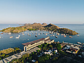 Der Hafen von Labuan Bajo mit einem im Meer segelnden Boot und dem Stadtbild, Touristenziel in Indonesien.