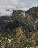 Luftaufnahme einer Bergkette mit tief hängenden Wolken auf der Insel Madeira, Portugal.
