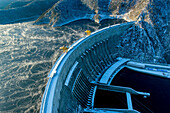 Aerial view of the impressive Neporozhny Sayano Shushenskaya hydro power plant surrounded by majestic mountains and a frozen river, Khakassia Republic, Russia.