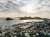 Der Hafen von Labuan Bajo mit einem im Meer segelnden Boot und dem Stadtbild, Touristenziel in Indonesien.