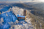 Panoramic aerial view of the snowcovered castle Yburg with mountains in the background, Black Forest, Baden Wine Route, Germany.