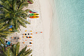 Luftaufnahme eines tropischen Strandes mit Kajaks und Kanus unter Palmen, Thoddoo, Malediven.
