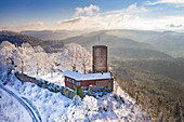 Panoramic aerial view of the snowcovered castle Yburg with mountains in the background, Black Forest, Baden Wine Route, Germany.