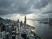 Luftaufnahme der atemberaubenden Wolkenkratzer und des Hafens unter einem bewölkten Himmel, Wan Chai, Hongkong.