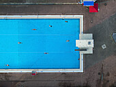 Aerial view of vibrant public pool with swimmers and diving board, Neukolln, Germany.