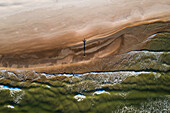 Aerial view of person silhouette shadow standing on Baltic sea shore beach in Klaipeda, Lithuania. Perspective of beautiful nature patterns on surface.