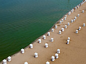 Aerial view of strandbad wannsee public beach with sandy shore and colorful umbrellas, Nikolassee, Germany.