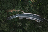 Aerial view of cars driving on curved mountain road in green jungle landscape, Ella town, Sri Lanka.