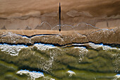 Aerial view of person silhouette shadow standing on Baltic sea shore beach in Klaipeda, Lithuania. Perspective of beautiful nature patterns on surface.