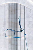 Aerial view of handstanding person silhouette shadow on stairs in public city square with concrete surface in Kaunas, Lithuania.