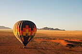 Luftaufnahme des Heißluftballons kurz vor dem Abheben im Licht des frühen Morgens. Namib-Wüste, NamibRand Naturreservat, Namibia.