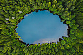 Aerial view of tiny round ice age lake in the middle of the Autumn forest near Moletai, Lithuania.