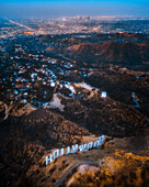 Los Angeles, United States - 25 July 2018: Aerial view of the Hollywood sign on the hilltop at sunset with Los Angeles skyline in background, California, United States.