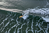 Aerial view of surfer surfing waves in winter time in Baltic sea near Klaipeda, Lithuania.