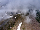 Aerial view of majestic snowy mountains under cloudy skies at Babusar Pass, Khyber Pakhtunkhwa, Pakistan.
