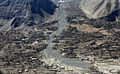Luftaufnahme eines abgelegenen Bergdorfs und terrassierter Felder am Fluss in Skardu, Gilgit-Baltistan, Pakistan.