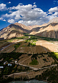 Luftaufnahme eines atemberaubenden und malerischen Tals, umgeben von majestätischen Bergen und einem ruhigen Dorf, Laspur, Pakistan