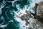 Aerial view of ocean breaking on rocks at Chapmans Peak Drive, Cape Town, South Africa.