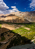 Luftaufnahme von majestätischen Bergen und einem ruhigen Tal mit üppigem Grün unter einem wunderschönen Himmel, Laspur, Pakistan
