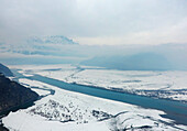 Aerial view of snowy mountains, river, and valley in serene Skardu, Punjab, Pakistan.