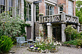Historic building with balcony, rose bed and seating area in the garden