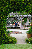 Gesellige Runde unter einer Pergola in einem historischen Garten