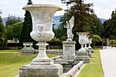 Steinerne Pflanzgefäße und Engelsstatue in Powerscourt Gardens (Irland)