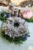 Kranz aus getrockneten Hortensien, Rosmarin und Lavendel auf Tischdecke mit Häkelspitze