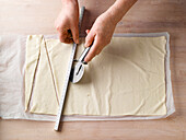 Teigplatte mithilfe eines Lineals versetzt in Dreiecke schneiden