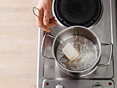 Ausgedrückte Blattgelatine in einem Topf bei schwacher Hitze auflösen