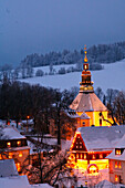 Verschneites Seiffen im Erzgebirge bei Dämmerung, beleuchtete Kirche