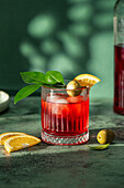 Campari cocktail with ice, olive and orange slice