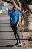 Young man skateboarding with face mask