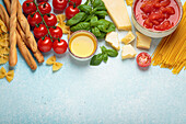 Italian ingredients - tomato sauce, grissini, pasta, basil, parmesan and olive oil