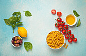 Ingredients for Italian pasta dishes - tomatoes, olives, basil, oil