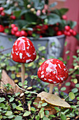 Herbstdeko: Fliegenpilze aus Keramik mit Mühlenbeckia und Scheinbeere