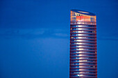 Der Torre Sevilla ragt majestätisch in den Dämmerungshimmel und zeigt seine einzigartige Architektur und seine leuchtenden Lichter, wenn der Tag in die Nacht übergeht.