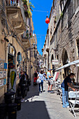 Cafes, restaurants and shops in a street of Ortigia, Sicily