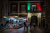 Mit den Farben der italienischen Flagge beleuchtete Fassade des Rathauses in Monopoli, Italien