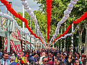 Seville, Spain, May 8 2025, Crowds gather at the Feria de Abril in Seville, celebrating with bright paper lanterns and enjoying traditional Andalusian culture.