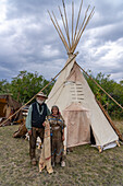 An older couple in period dress in front of their tipi at the Fort Bridger Mountain Man Rendezvous in Wyoming.