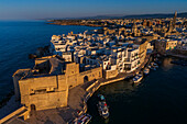 Aerial view of Porto Antico, the historic old port, the Marina, Castello Carlo V and the old town, Monopoli, Italy