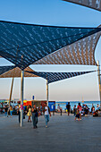 Shaded area with awnings on Barceloneta beach at sunset, Barcelona, Spain