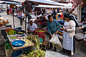 Men selling corn and other produce in the open market in Otavalo, Ecuador.