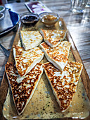 Delicious grilled goat cheese appetizer arranged on a plate with local sauces in Lanzarote, showcasing Canarian culinary traditions.