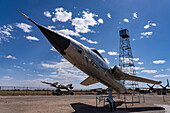 A Republic F-105 Thunderchief fighter-bomber at the National Museum of Nuclear Science. Albuquerque, New Mexico. Behind is a replica of the Trinity Site tower.